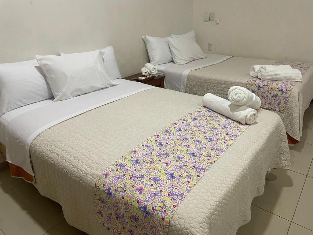 2 letti posti uno accanto all'altro in una stanza di Casita Cocoa a Santa Cruz Huatulco