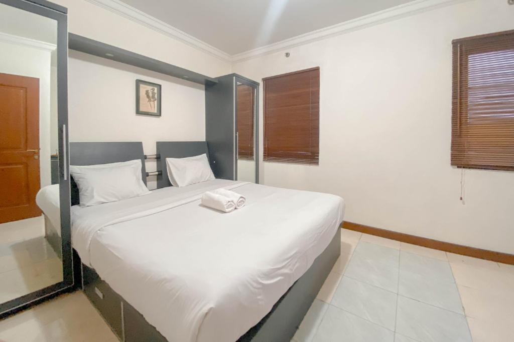 a bedroom with a large white bed in a room at Spacious Luxury 2BR at Majesty Apartment By Travelio in Bandung