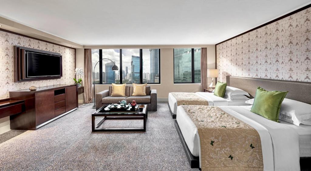 a hotel room with two beds and a tv at Mandarin Oriental, Jakarta in Jakarta
