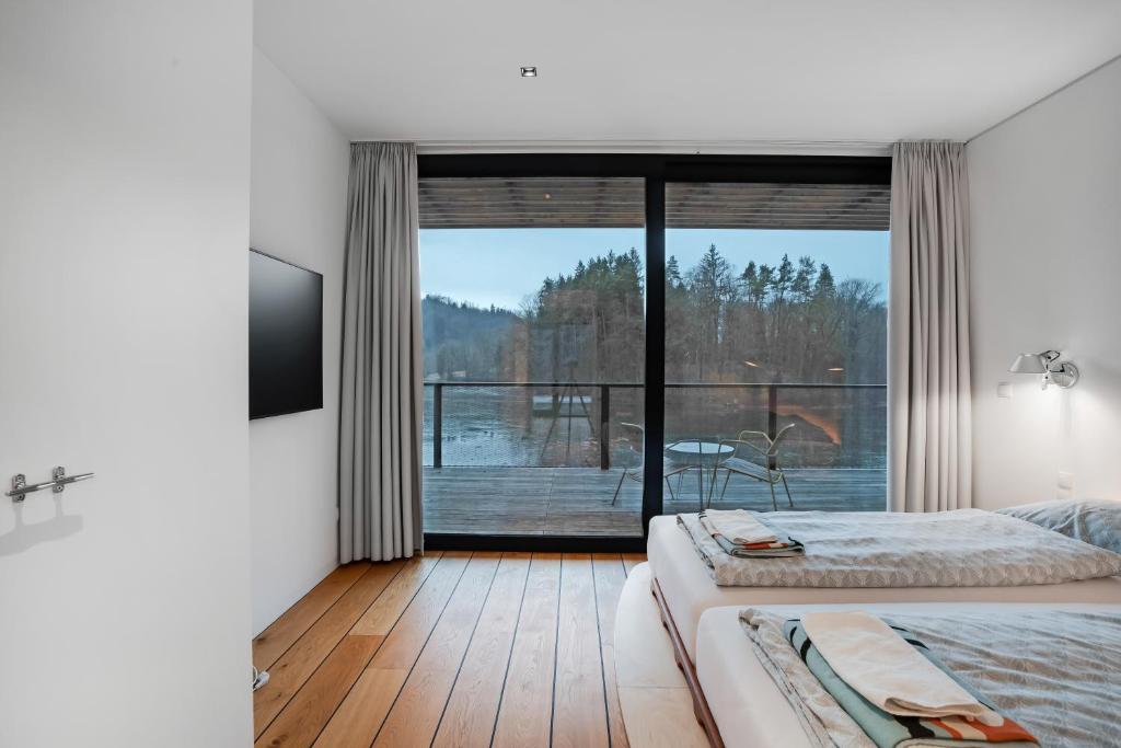 Postel nebo postele na pokoji v ubytování Idyllische Seeblick-Apartments - Auszeit am Thaler See Garten Graz