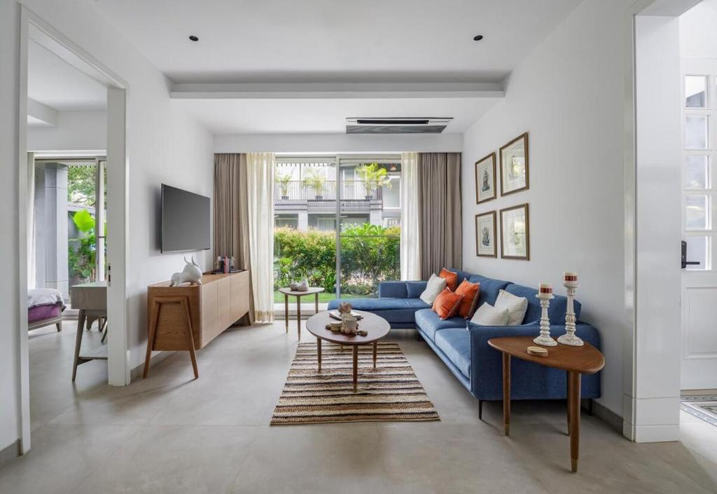 Una sala de estar con un sofá azul y una mesa. en Luxury Villa- Casa VedaAssagao, en Chandīgarh