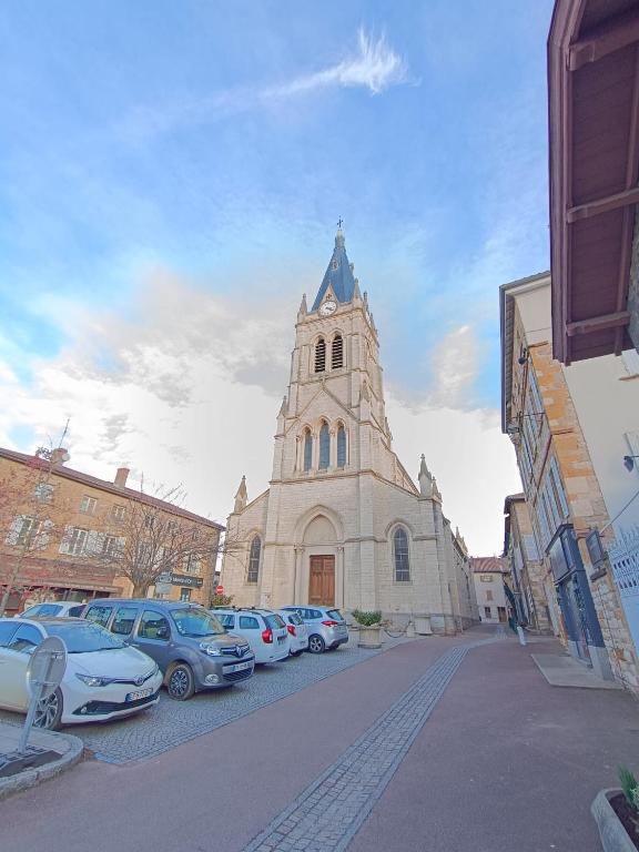 une église avec des voitures garées devant dans l'établissement Duplex du Cuchet Aux portes de la Gastronomie, à Chasselay