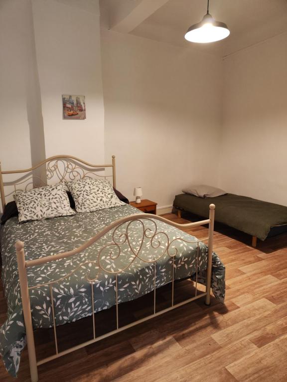 a bedroom with a bed and a futon in it at Apt capitale du Luberon appartement 3 chambres 4 lits in Apt