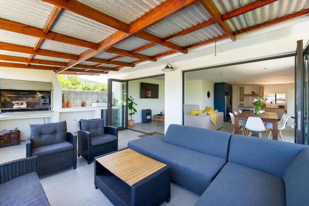 a living room with a blue couch and chairs at Seaside Family Villa in Wilderness