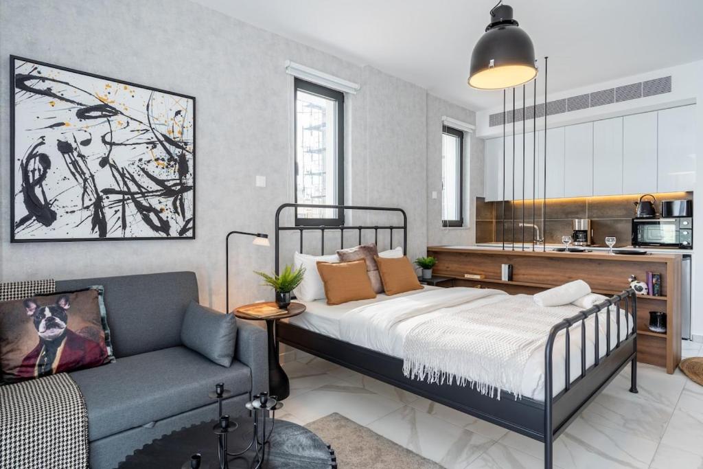 een slaapkamer met een bed en een bank bij Dusk - Harmonic Studio by Plus 49 in Mackenzie in Larnaka