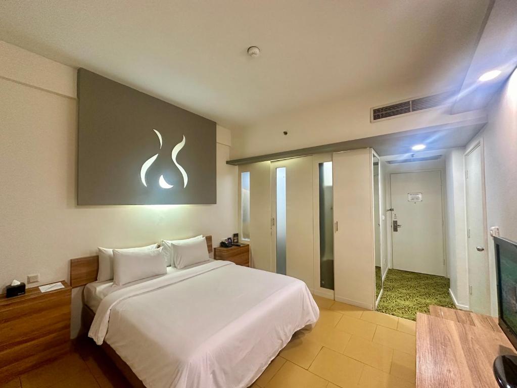 Postel nebo postele na pokoji v ubytování Sparks Life Jakarta, ARTOTEL Curated