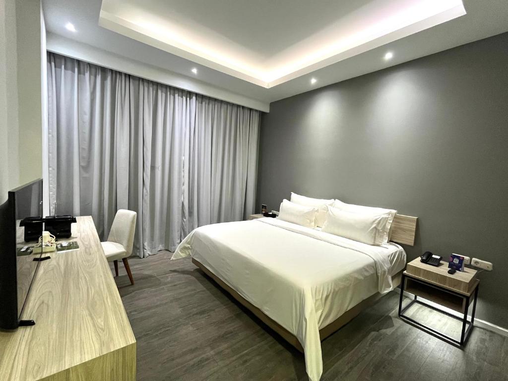Postel nebo postele na pokoji v ubytování Sparks Life Jakarta, ARTOTEL Curated