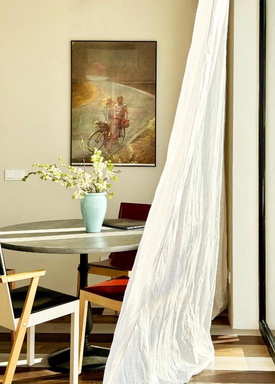 a dining room with a table and a painting at Laimingi namai in Palanga