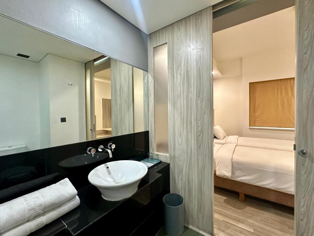 Postel nebo postele na pokoji v ubytování Sparks Life Jakarta, ARTOTEL Curated