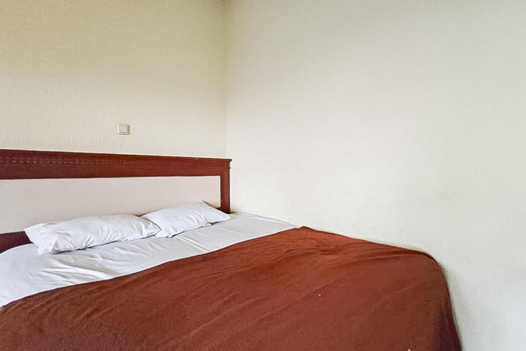 a bed with two pillows on it in a room at Villa Dua Sisi RedPartner in Paragajen