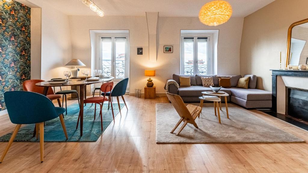 un salon avec un canapé, une table et des chaises dans l'établissement Les Toits de Darcy - Dijon Centre historique, à Dijon
