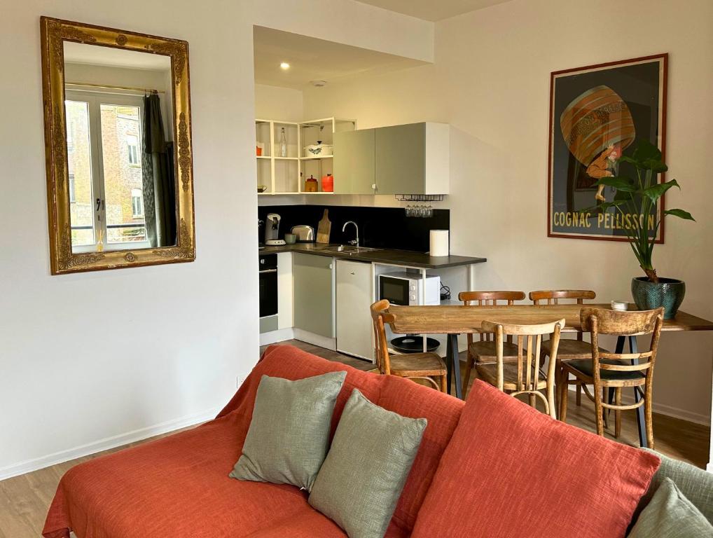 una sala de estar con un sofá y una mesa en BO'M Appart, en Tourcoing