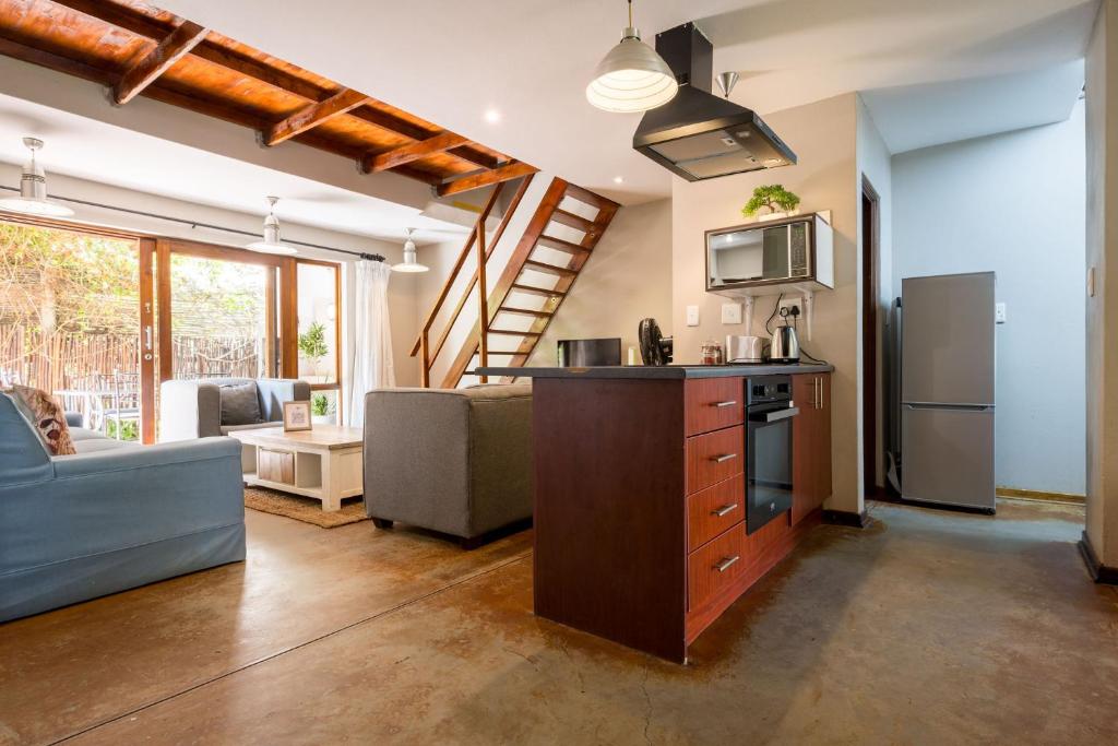 a kitchen and living room with a couch and a stove at Raptors Wildlife Escapes in Hoedspruit