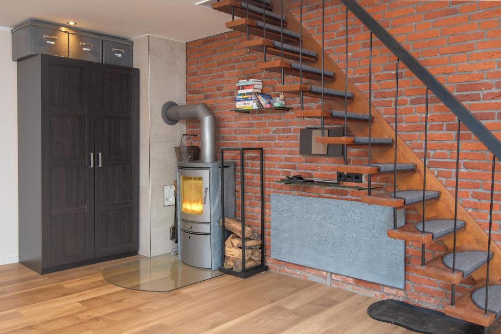 Eine Backsteinmauer mit einem Holzofen neben einer Treppe in der Unterkunft Huus Gerda in Krummhörn