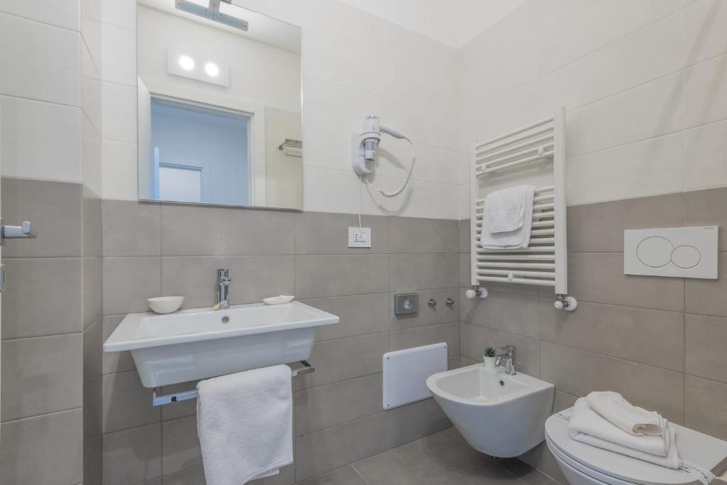 łazienka z umywalką, toaletą i lustrem w obiekcie Casole Living B&B w mieście Copertino