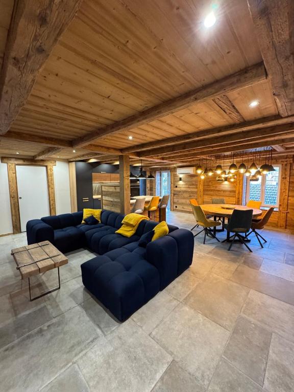 un grand salon avec un canapé bleu et une table dans l'établissement Le grand cerf, à Gérardmer