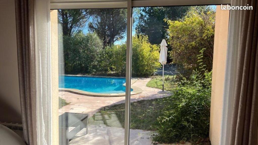 a view of a swimming pool through a window at Villa avec piscine in Châteauneuf-de-Gadagne
