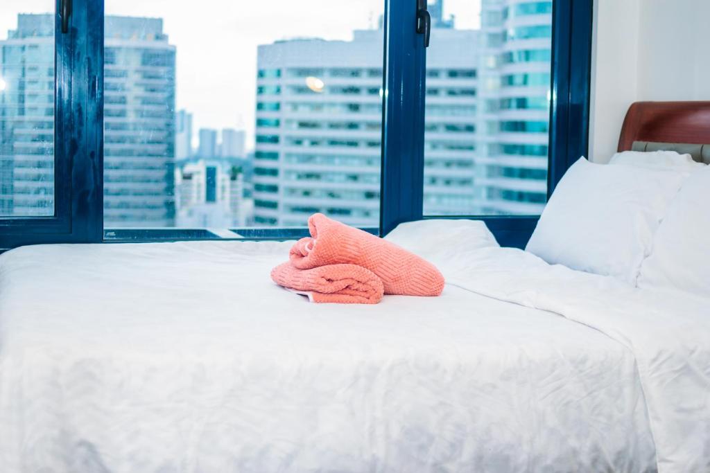 a bed with two towels on it with a window at Quirky Urban Luxury Nest 1 Blazing fast 300Mbps in Manila