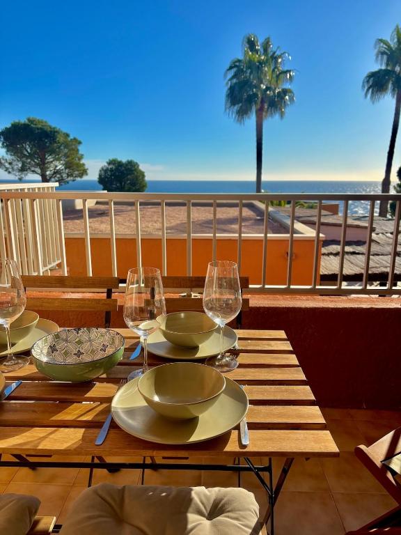 - une table avec des verres à vin sur un balcon donnant sur la plage dans l'établissement Nautica - Appart 4 personnes vue mer, idéal famille, à Théoule-sur-Mer