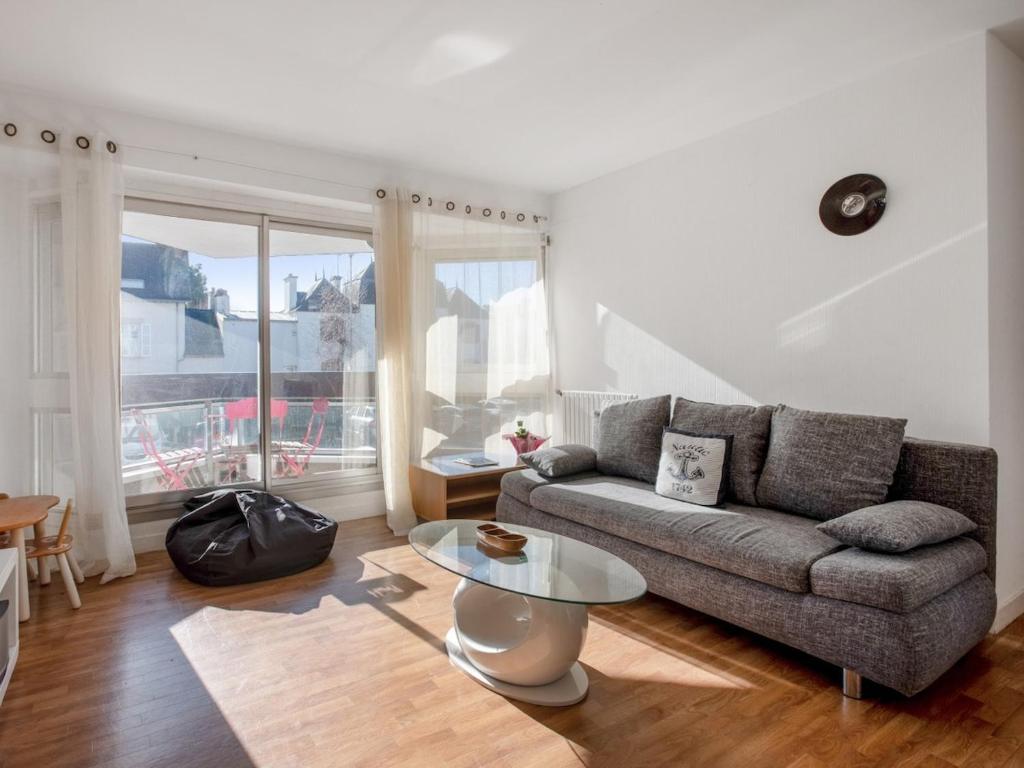un salon avec un canapé et une table dans l'établissement Proche du port avec balcon - Kerlaouen, à Vannes