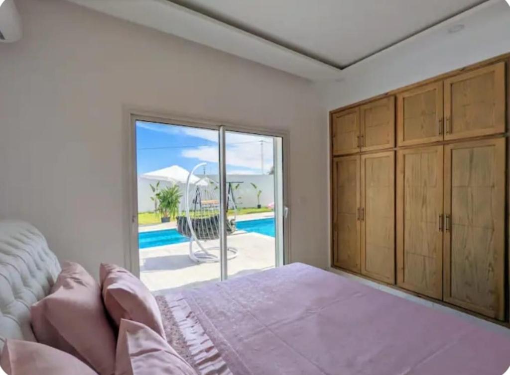 a bedroom with a bed and a view of a pool at Wonderful villa rental with swimming pool in Arkou