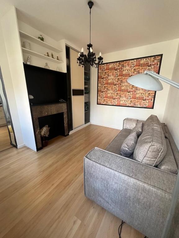 un salon avec un canapé et un mur de briques dans l'établissement Evasion Côtière,Studio à 2 pas de la plage, à Dunkerque