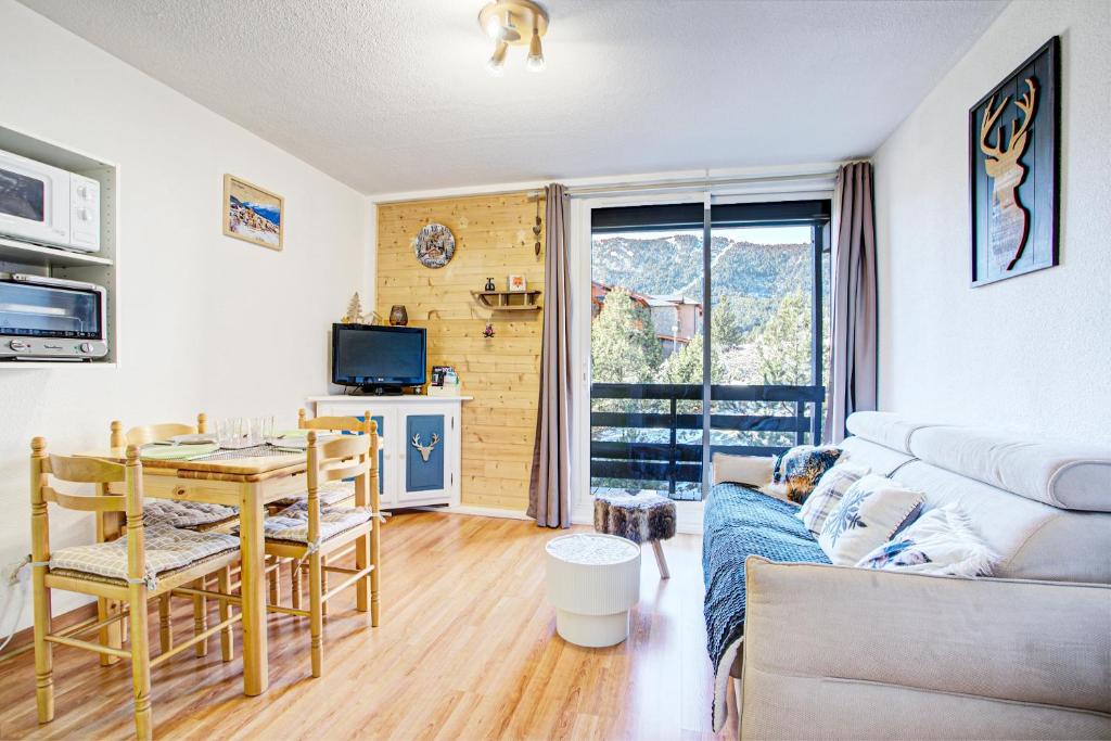 a living room with a table and a dining room at Le Petit Montagnard - Station accessible à pied in Les Angles