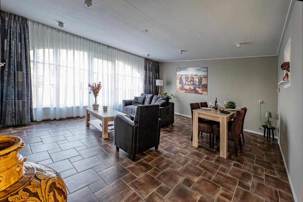 a living room with a couch and a table at Aan `t Krakeel in Noordscheschut