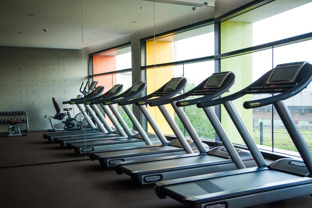 a row of treadmills in a gym with windows at Eslite Hotel in Taipei