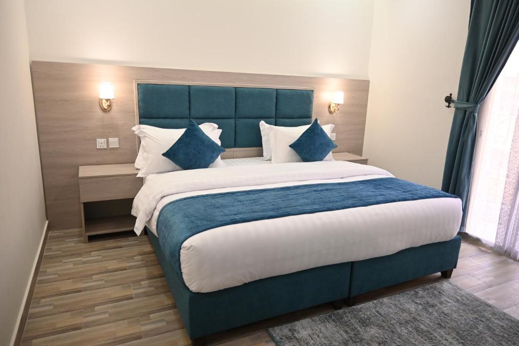 una camera da letto con un letto grande con cuscini blu e bianchi di ان هاوس ون a Al Khobar