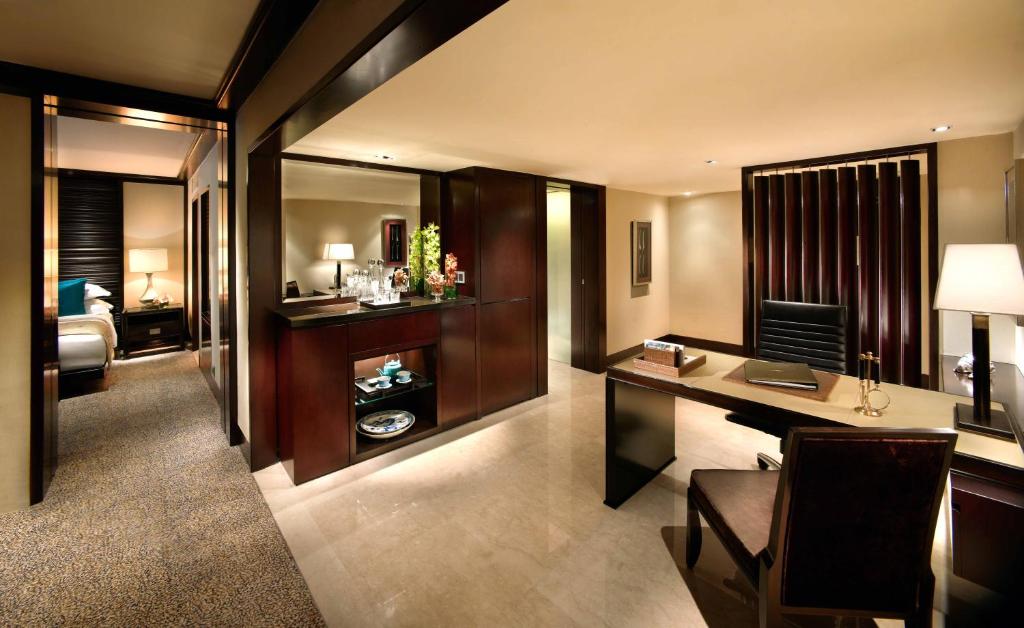 a room with a desk and a room with a bed at Mandarin Oriental, Jakarta in Jakarta