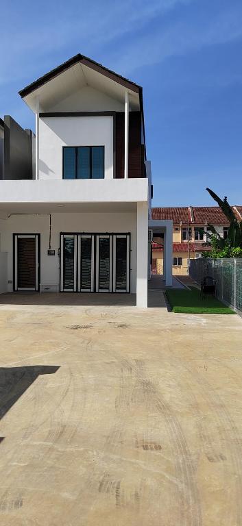 a large white house with a large driveway at Mars Homestay in Alor Setar