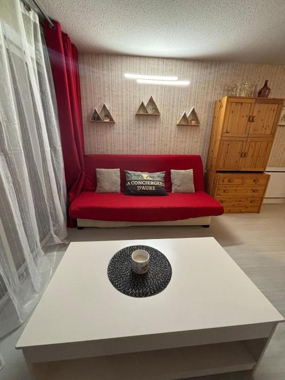 un salon avec un canapé rouge et une table dans l'établissement Bel T2 in St Lary - Résidence Lustou, à Saint-Lary-Soulan