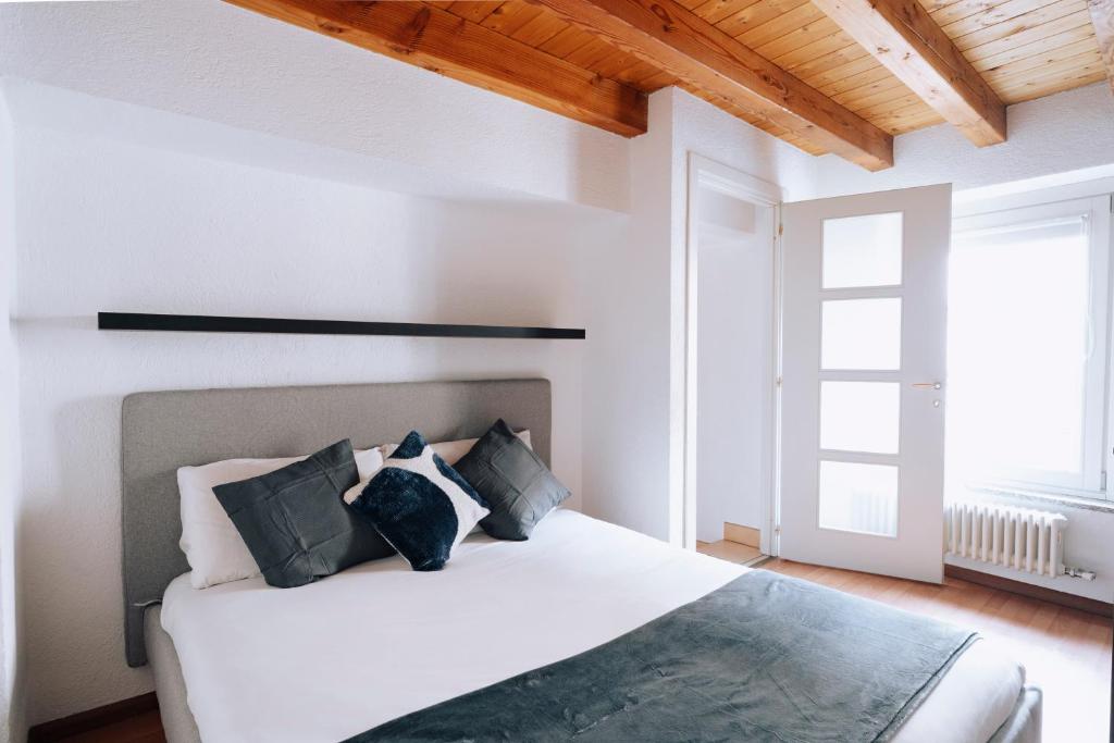 アオスタにあるAosta Holiday Apartments - Mailletのベッドルーム(白いベッド、黒い枕付)