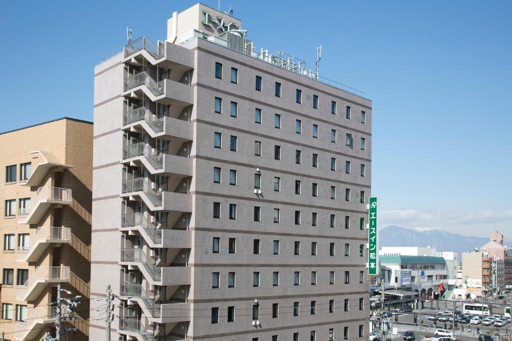 松本市にあるエースイン松本の緑の看板が立つ高い灰色の建物