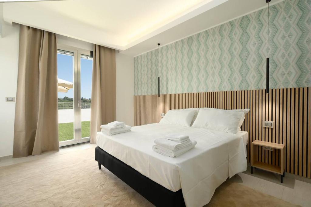 ein Schlafzimmer mit einem großen weißen Bett und einem Fenster in der Unterkunft Villa Persea in Santa Venerina