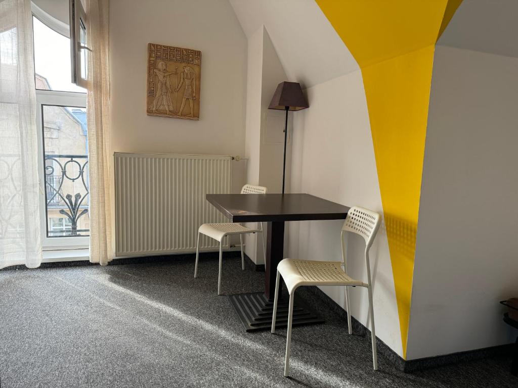 a dining room with a black table and chairs at Absynt Hostel Wrocław in Wrocław