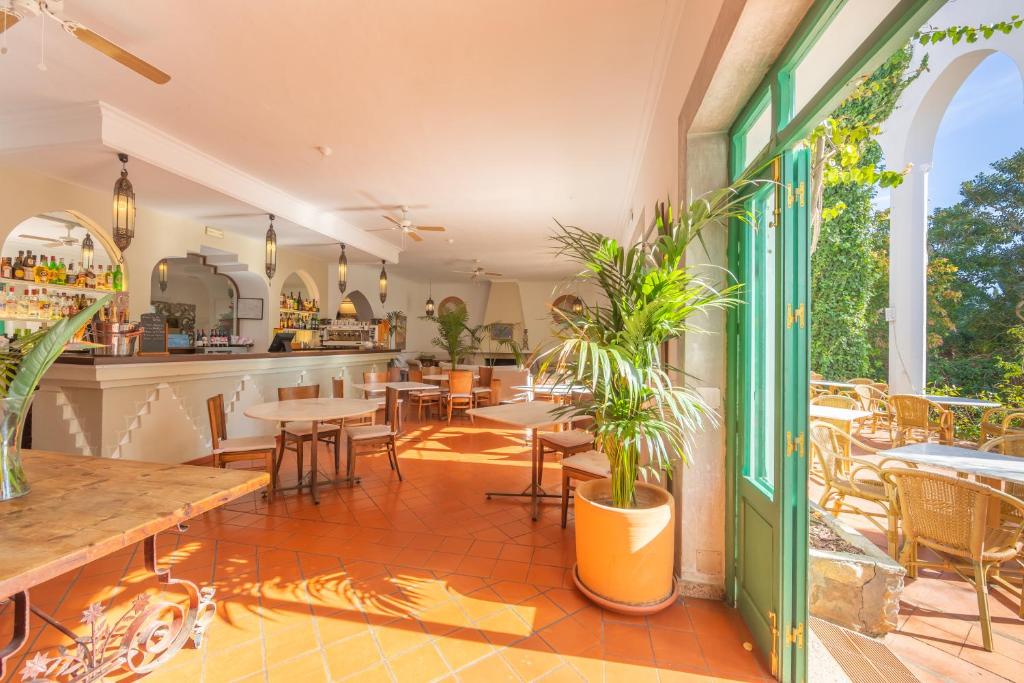 a restaurant with tables and chairs on a patio at Hurricane Beach Hotel in Tarifa