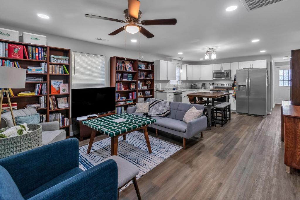 a living room with couches and a tv and a kitchen at Charming Pet Friendly Concord Retreat home in Concord