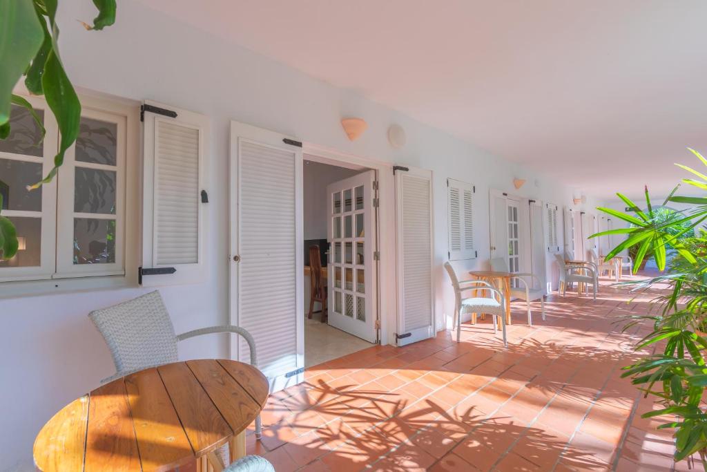 a patio with a wooden table and chairs in a room at Hurricane Beach Hotel in Tarifa