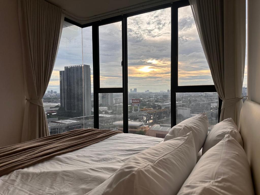 เตียงในห้องที่ Entire apartment near train station with pool & views