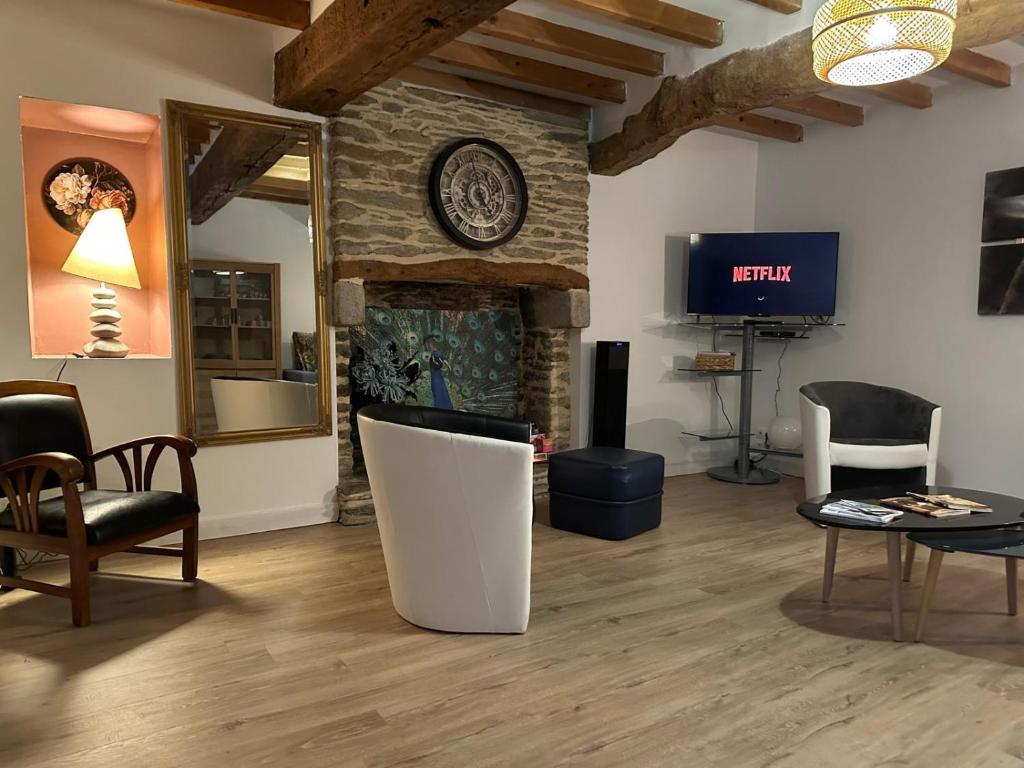 ein Wohnzimmer mit Kamin und Fernseher in der Unterkunft Évasion à Hainneville in Cherbourg en Cotentin