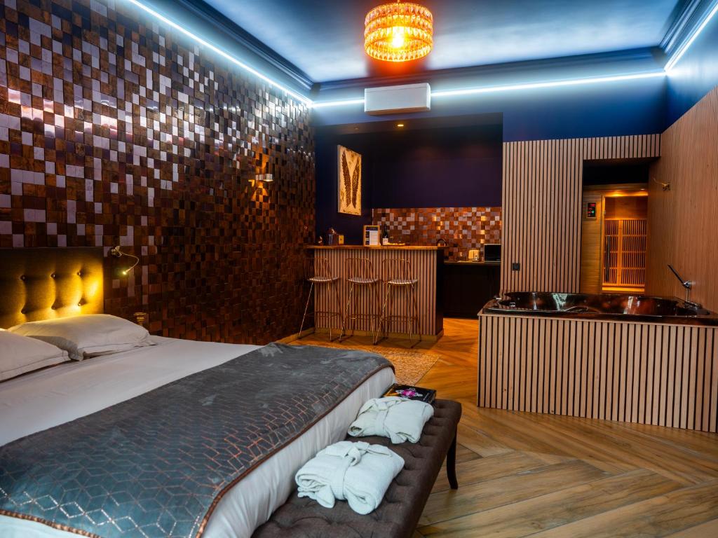a bedroom with a bed and a tub in a room at Le Voluptueux - Sauna - Jacuzzi - Centre-Ville in Angers