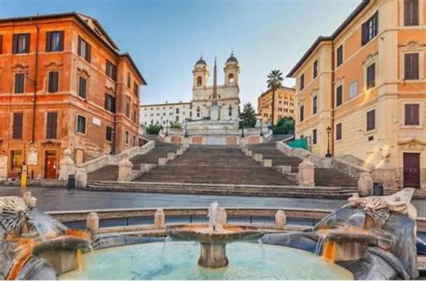 a building with a fountain in the middle of a street at Spagna Boutique Suites in Rome