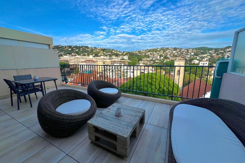 Elle comprend un balcon doté d'un mobilier en osier et offrant une vue sur la ville. dans l'établissement Golfe Juan - 2 people - Top floor - Parking, à Vallauris