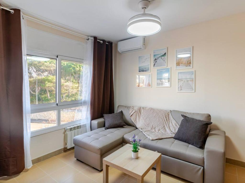 un salon avec un canapé et une fenêtre dans l'établissement Lloret de Mar Coastal Retreat Just Steps from the Beach, à Lloret de Mar