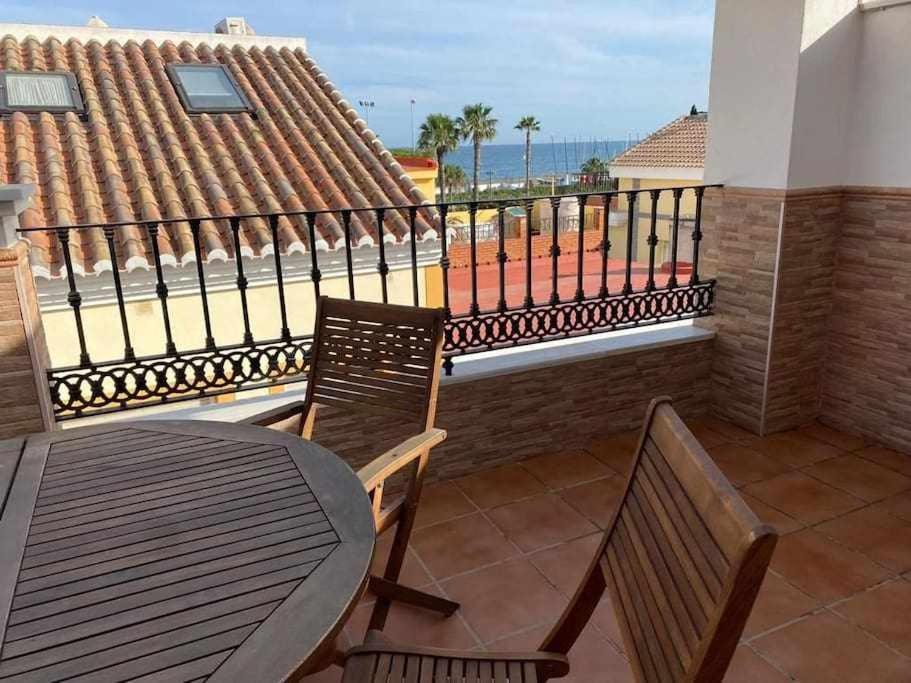 balkon ze stołem i krzesłami i widokiem na ocean w obiekcie Apartamento Club Nautico By Solymar Holiday w mieście Torre del Mar