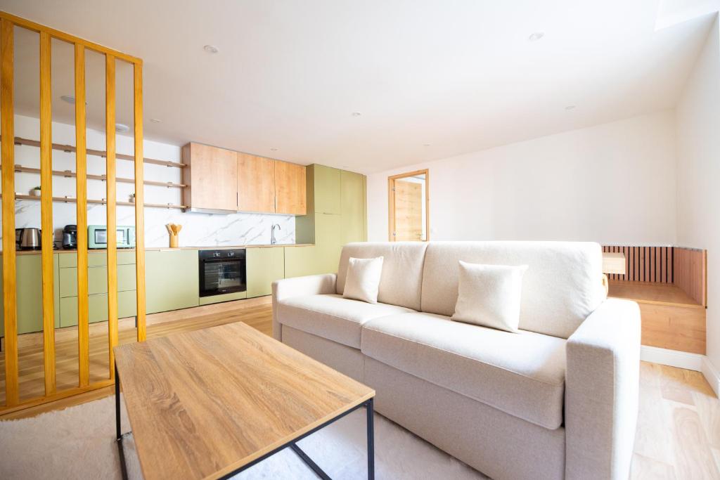 un salon avec un canapé blanc et une table dans l'établissement CIA - Les Halles-Rivoli 6P, à Paris