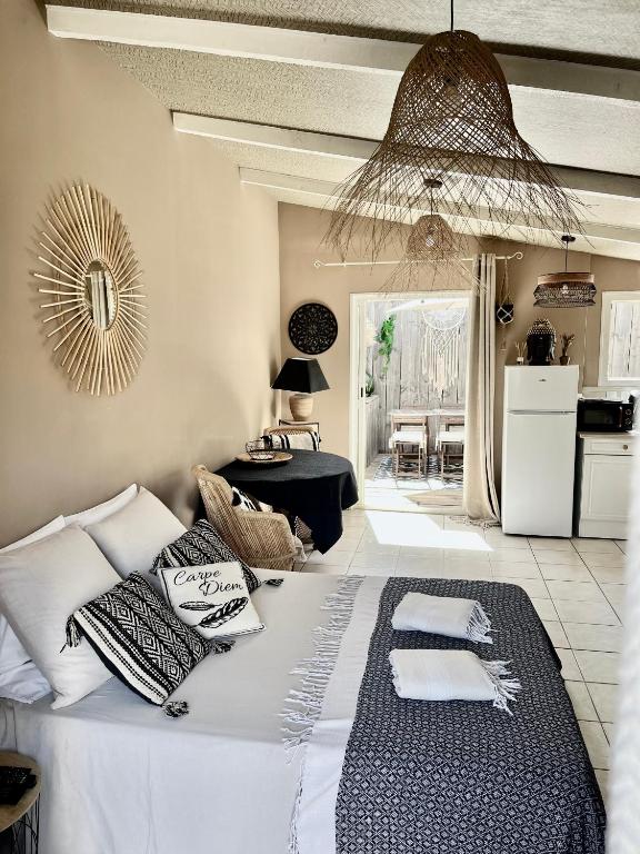 une chambre avec un grand lit avec des oreillers dessus dans l'établissement La Cabane du Mas Andalou Plage première ligne de mer, à Frontignan