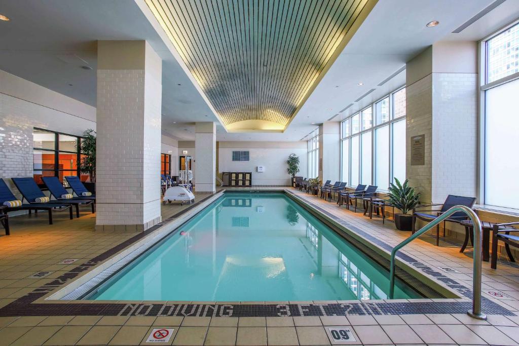 a large swimming pool in a building with chairs at Embassy Suites by Hilton Chicago Downtown Magnificent Mile in Chicago
